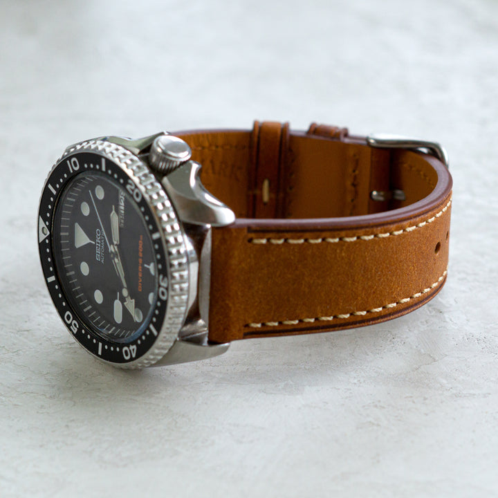 Watch with a brown leather strap on a light gray background #color_cognac