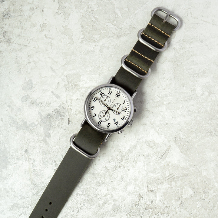 Watch with a green strap on a textured light gray background #color_green