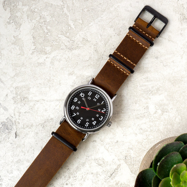 Watch with brown leather strap on a light gray surface #color_dark-brown-pvd