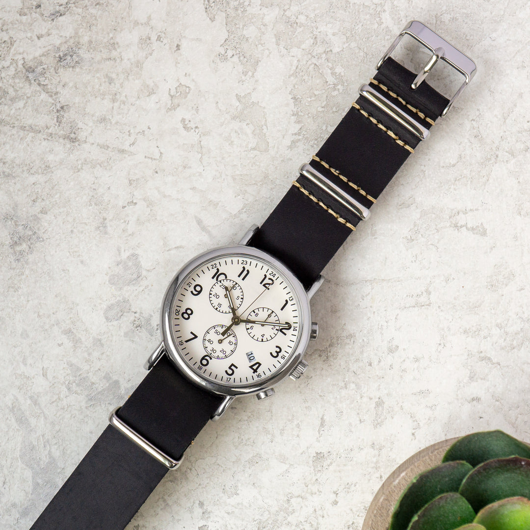 Wristwatch with black strap on a textured surface #color_black