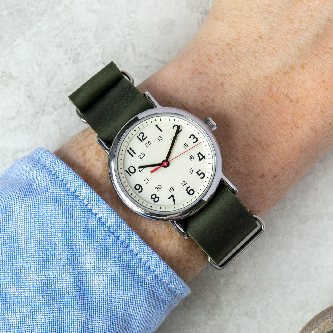 Wrist wearing a watch with a green strap on a light background #color_green