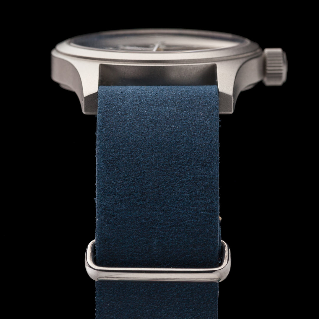 Watch with a blue strap and silver case on a black background #color_navy-blue