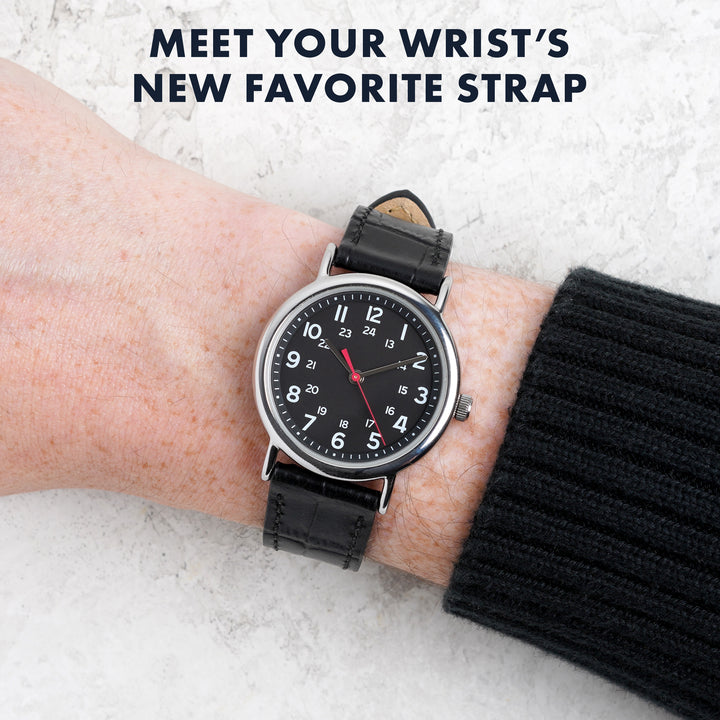Person wearing a black wristwatch with a leather strap on a light background #color_black