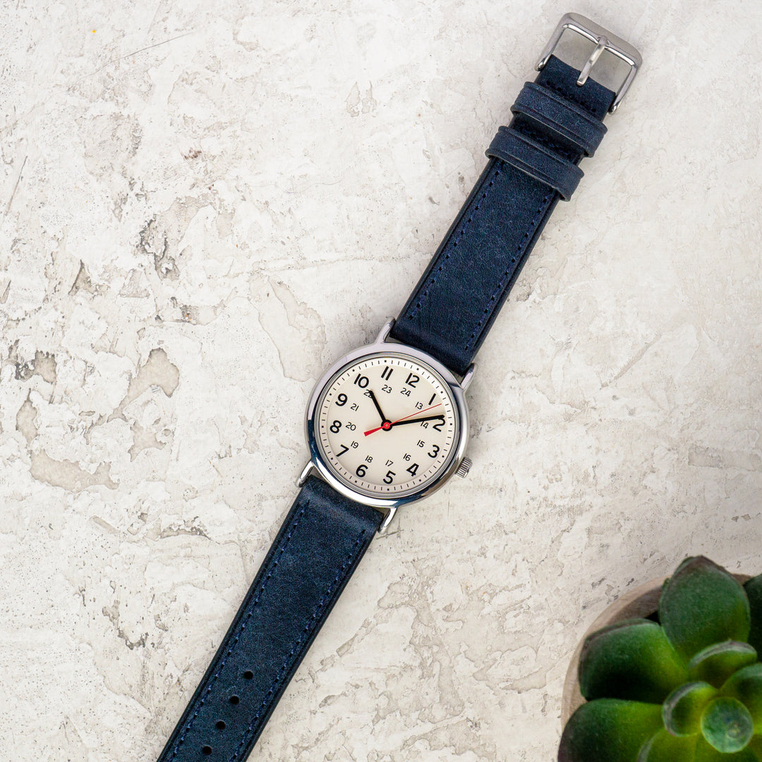 Wristwatch with blue strap on a light stone surface #color_navy-blue