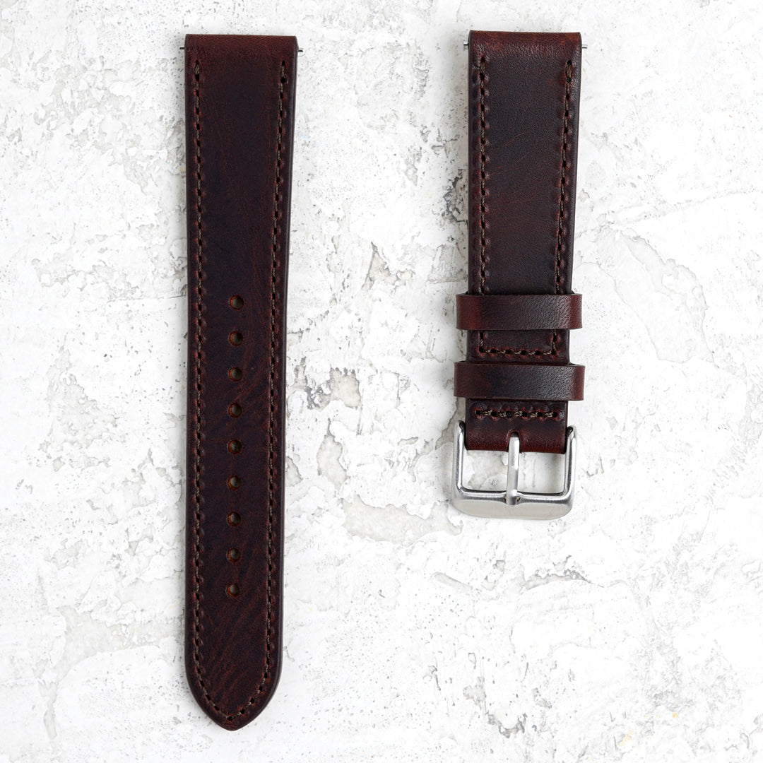 Brown leather watch strap with silver buckle on a light gray background #color_dark-brown