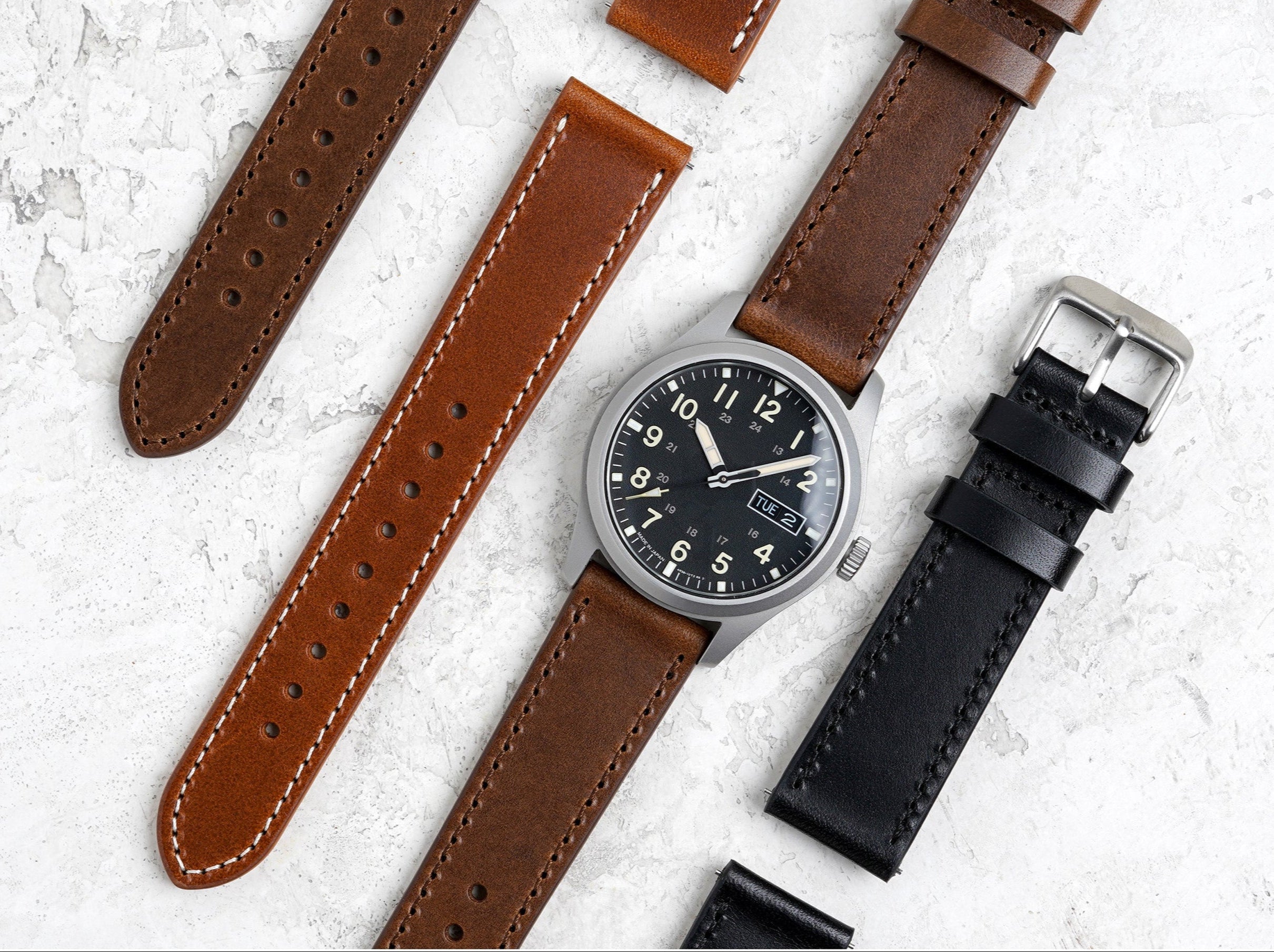 Butterero leather watch band with Benchmark Basics branding on a textured white background
