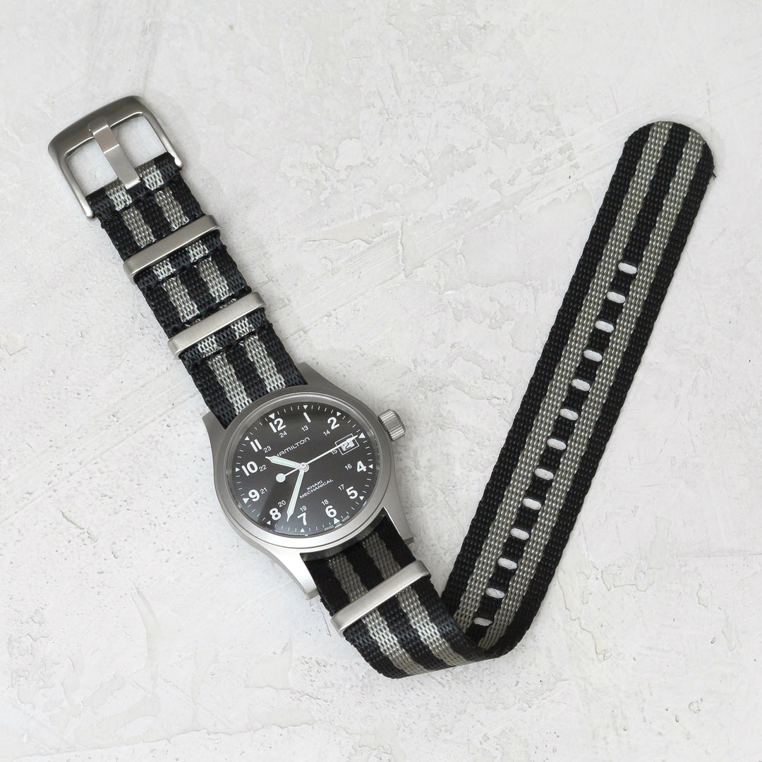 Wristwatch with a black and gray striped strap on a light gray background #color_black-and-grey-regimental-striped